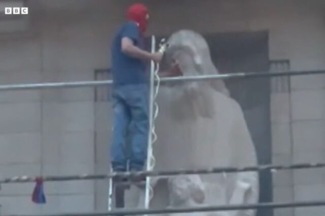 BBC: Άνδρας σκαρφάλωσε στην πρόσοψη κτιρίου στο Λονδίνο για να καταστρέψει αμφιλεγόμενο άγαλμα