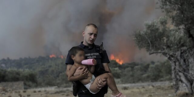 Φωτιά στα Δερβενοχώρια: Αστυνομικός παίρνει παιδί αγκαλιά για να το σώσει από τις φλόγες