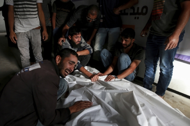 Παλαιστίνιοι θρηνούν πάνω από τις σορούς συγγενών που σκοτώθηκαν σε ισραηλινή αεροπορική επιδρομή στη Ράφα.