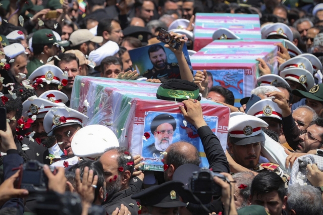 Ιρανοί ακολουθούν ένα φορτηγό που μεταφέρει φέρετρα του εκλιπόντος προέδρου Εμπραχίμ Ραΐσι και των συντρόφων του που σκοτώθηκαν σε συντριβή ελικοπτέρου την Κυριακή