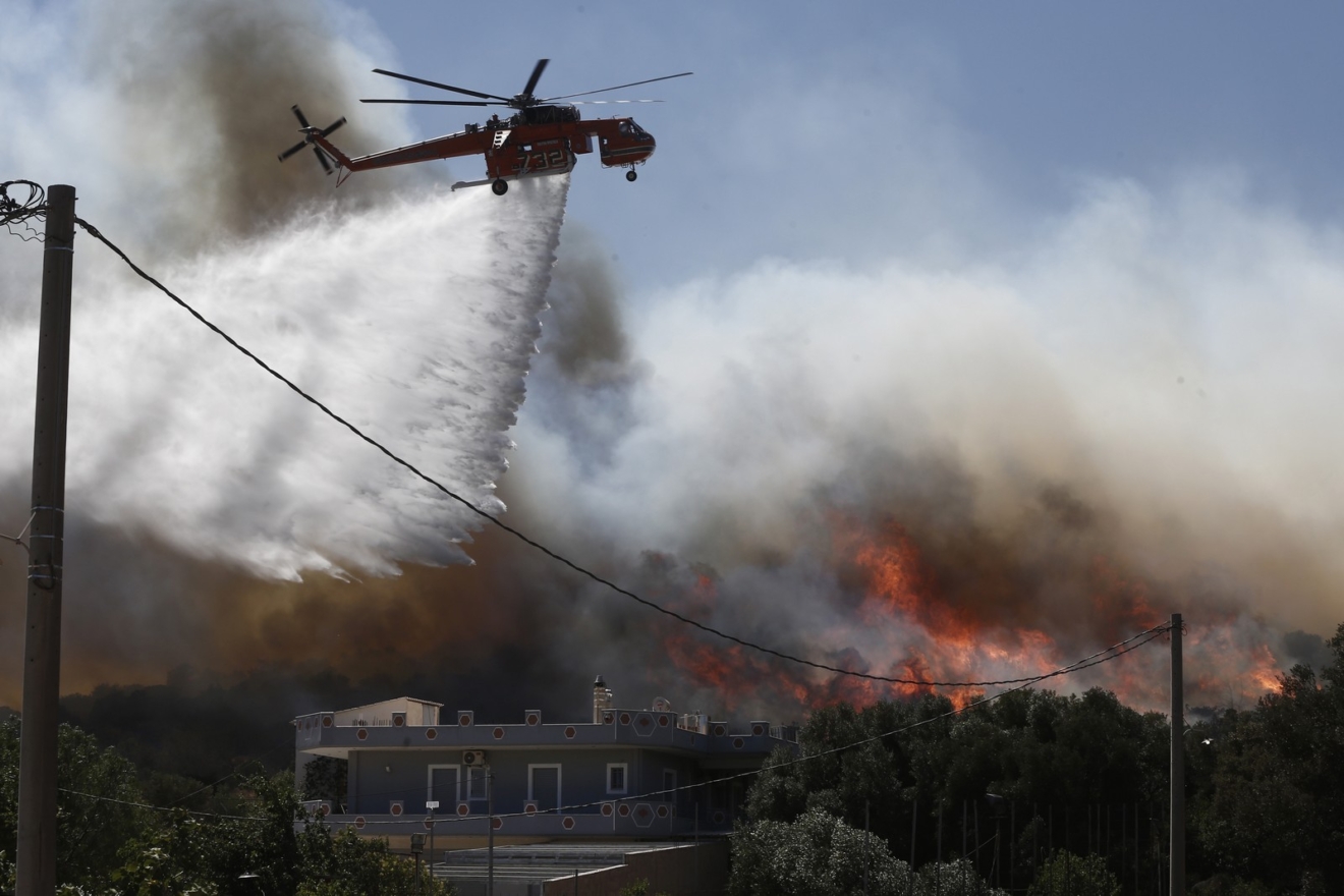 Πυροσβεστικό ελικόπτερο πραγματοποιεί ρίψεις νερού κατά τη διάρκεια φωτιάς στον οικισμό Κίτσι