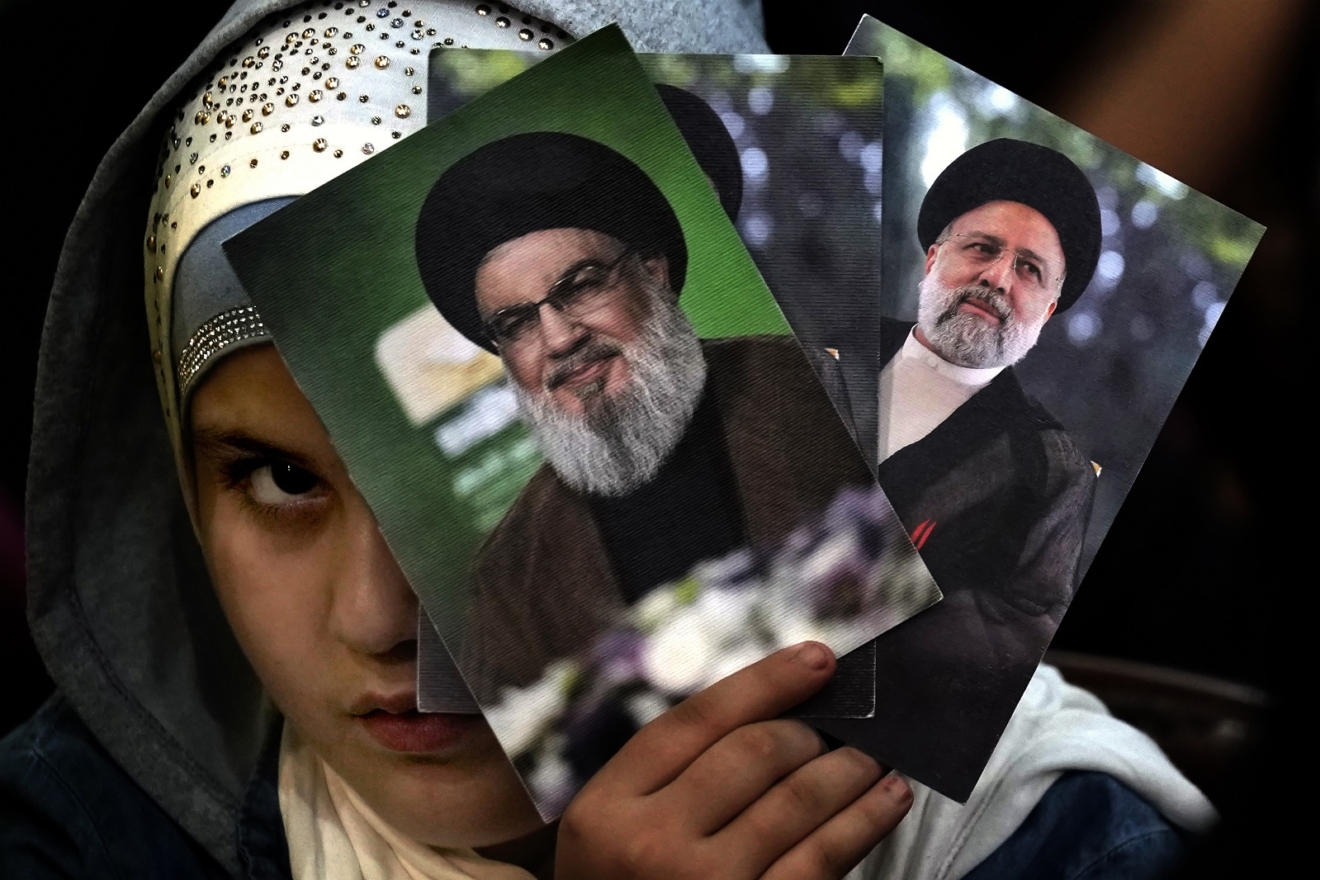 Ένα παιδί στο Λίβανο κρατά τις φωτογραφίες του ηγέτη της Χεζμπολάχ και του αποθανόντος Προέδρου του Ιράν