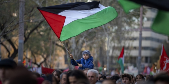 Ένα αγόρι ανεμίζει μια παλαιστινιακή σημαία κατά τη διάρκεια μιας διαμαρτυρίας στη Βαρκελώνη για την υποστήριξη των Παλαιστινίων και την έκκληση για άμεση κατάπαυση του πυρός στη Γάζα