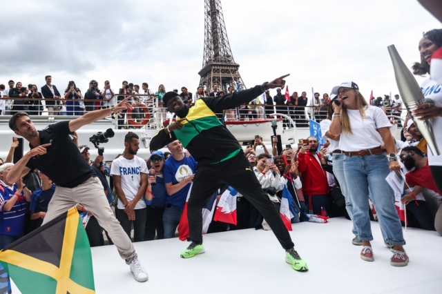 Ο Τζαμαϊκανός «συνταξιούχος» σπρίντερ Usain Bolt και ο πρόεδρος της Οργανωτικής Επιτροπής του «Παρίσι 2024» Tony Estanguet εκτελούν την χαρακτηριστική κίνηση του Bolt κατά τη διάρκεια παρέλασης. Θα σπάσει κάποιος τα ρεκόρ του;