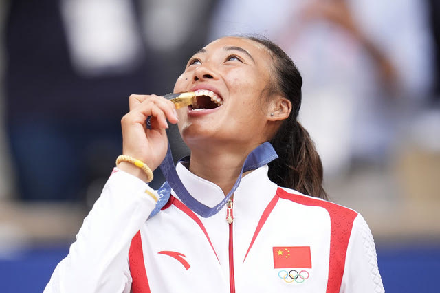 Η Κινέζα Zheng Qinwen δαγκώνει το χρυσό μετάλλιο μετά τη νίκη της επί της Κροάτισσας Donna Vekic στον τελικό τένις γυναικών στους Ολυμπιακούς Αγώνες του 2024