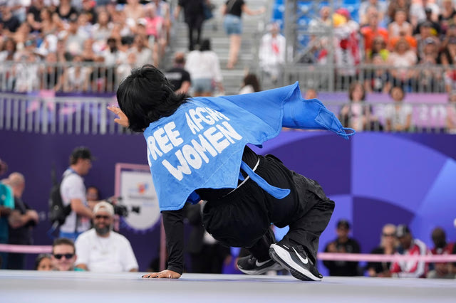 Refugee Team's Manizha Talash, known as Talash wears a cape which reads "free Afghan women" as she competes during the B-Girls Pre-Qualifier Battle of the breaking competition at La Concorde Urban Park at the 2024 Summer Olympics, Friday, Aug. 9, 2024, in Paris, France.