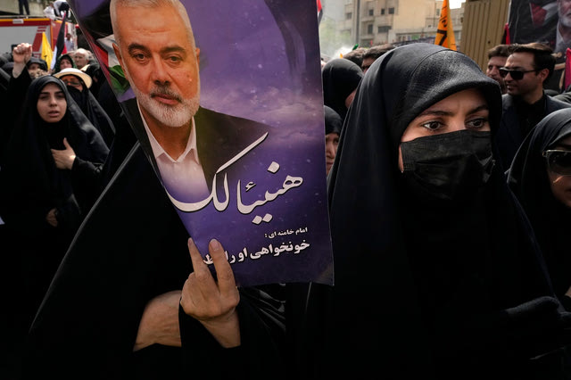 Γυναίκα κρατά αφίσα του Ισμαήλ Χανίγια στην Τεχεράνη