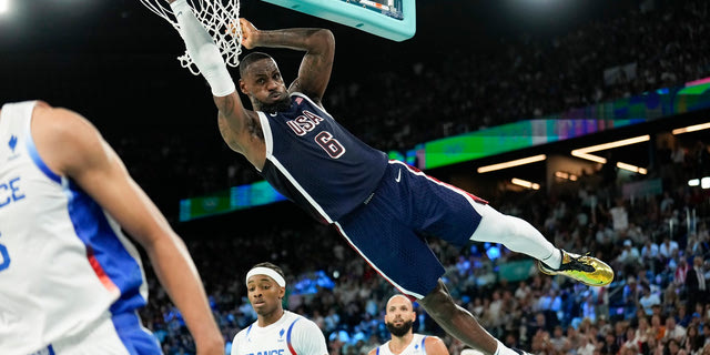 United States' LeBron James (6) dunks over Nicolas Batum (5), of France during a men's gold medal basketball game at Bercy Arena at the 2024 Summer Olympics, Saturday, Aug. 10, 2024, in Paris, France.