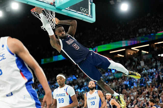 United States' LeBron James (6) dunks over Nicolas Batum (5), of France during a men's gold medal basketball game at Bercy Arena at the 2024 Summer Olympics, Saturday, Aug. 10, 2024, in Paris, France.