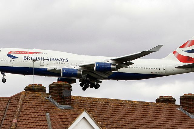 Αεροπλάνο της British Airways πετάει πάνω από στέγες καθώς προσγειώνεται στο αεροδρόμιο Χίθροου του Λονδίνου